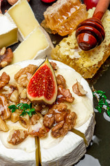 Camembert cheese and walnuts on stone serving board