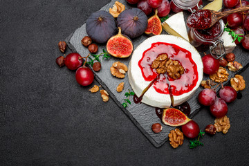 Camembert cheese and walnuts on stone serving board