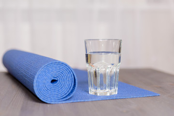 Blue yoga mat and glass of water