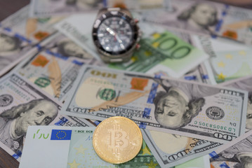Car key, chronograph and gold bitcoin on Euro and Dollars banknotes background