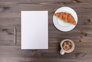 Coffee and croissant on wooden desk background top view mock up