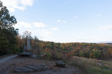 The 12th New York Regiment monument is a castle like structure on little round top, overlooking the valley below. It is autumn in Gettysburg, with fall colors on the trees