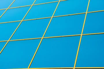 Window panels on a office building in the city with reflection of blue sky