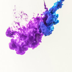 smoky splashes of blue and purple paint in water, isolated on white