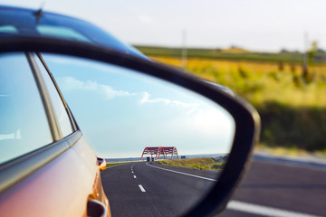 Landscape in sideview mirror of road and cars