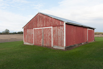 Faded red barn on grassy lot on a farm in the country