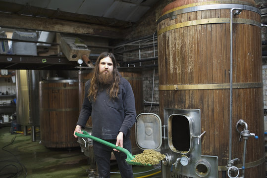 Portrait of a male beer brewer cleaning a brewery
