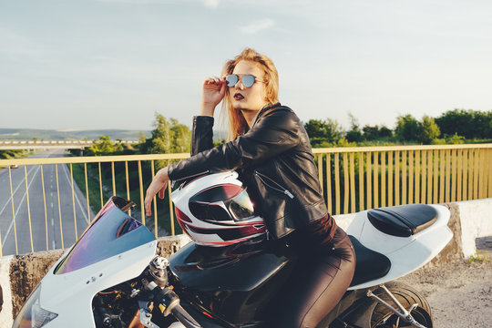 Beautiful woman with sunglasses driving on motorbike