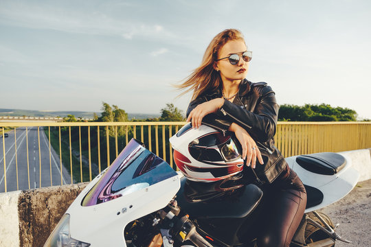Beautiful woman with sunglasses driving on motorbike
