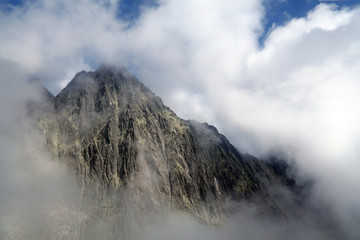 Rocky mountain ridge in foggy clouds