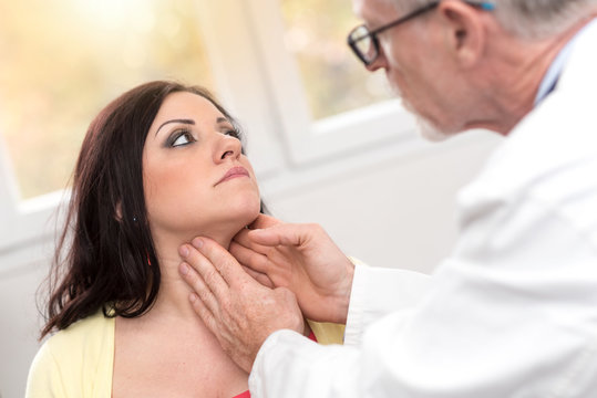 Doctor checking thyroid, light effect