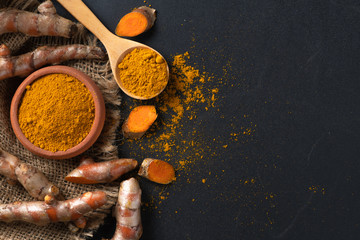 turmeric powder in spoon with turmeric root