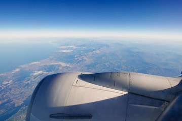 Fototapeta na wymiar View from plane window on engine and land.