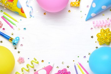 Birthday party caps, blowers, gifts, colorful balloons, serpentine and confetti on white background.