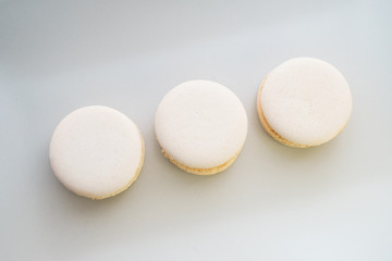 Delicious fresh traditional macaroon dessert cakes on a plate, on a wooden table with cacao and hot chocolate.