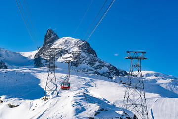 Fototapeta na wymiar Beautiful view of Alps covered with snow and red cable car to Matterhorn peak