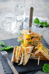 Delicious sandwich with ham, cheese, eggs, lettuce. High club sandwich with toast.