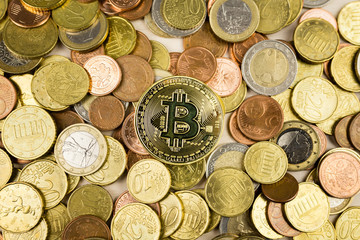 Bitcoin Coin and Euro coins on a table