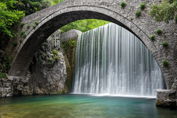 Traditional stone bridge and waterfall near Paleokaria village in Thessaly, Greece