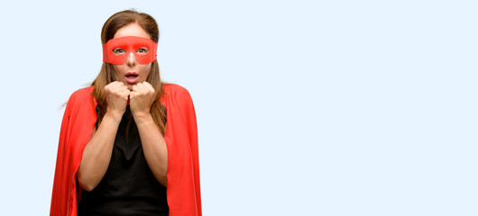 Middle age super hero woman wearing red mask and cape terrified and nervous expressing anxiety and...