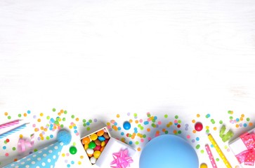 Holiday frame or background with colorful balloon, gift, confetti, silver star, carnival cap and streamer. Flat lay style. Birthday or party greeting card with copy space.