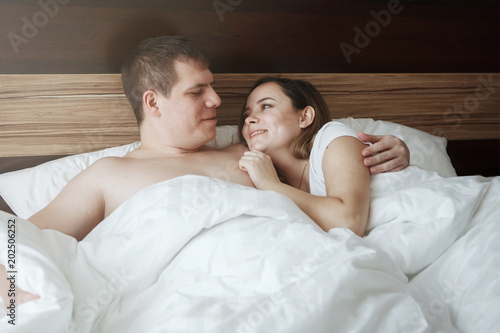 Young Beautiful Husband And Wife Resting In Bed Under A