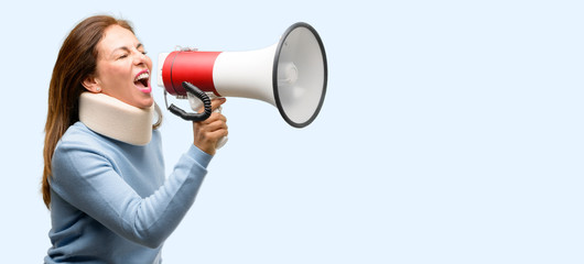 Injured woman wearing neck brace collar communicates shouting loud holding a megaphone, expressing success and positive concept, idea for marketing or sales isolated blue background