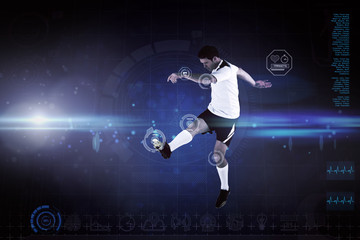 Football player in white kicking against blue dots on black background