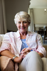 Senior woman sitting on sofa in living room