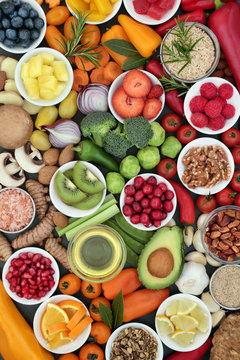 Food for healthy eating with fresh vegetables, fruit, herbs, spices, grains, nuts and seeds, forming a background. Foods very high in antioxidants, anthocyanins, minerals and vitamins.
