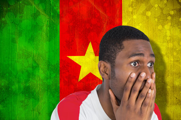 Nervous football fan looking ahead against cameroon flag in grunge effect