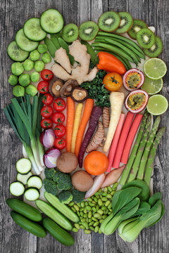 Healthy super food concept with fresh fruit and vegetables with food high in antioxidants, anthocyanins, vitamins, minerals and dietary fibre. Rustic abstract background, top view.
