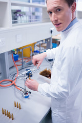 Portrait of a smiling biochemist sealing a vial