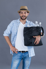 Man in fedora hat holding a bag full of plastic bottles