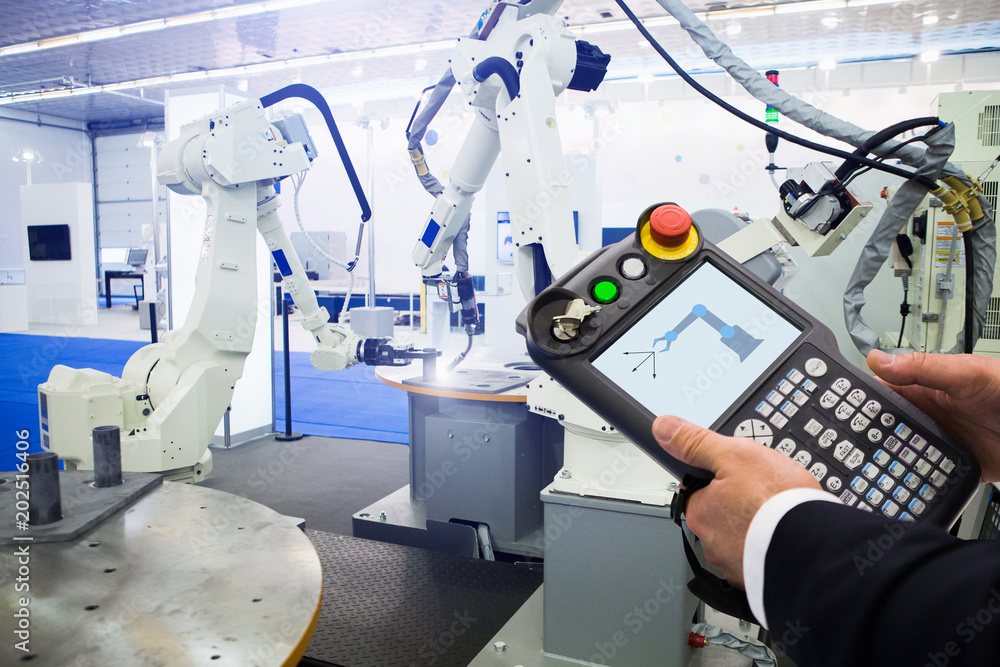 Aufkleber Engineer with teach pendant device. Programming robot with robotic arm. Smart factory 