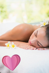 Obraz na płótnie Canvas Beautiful woman lying on massage table at spa center against heart