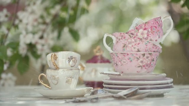 Cinemagraph - Cups of tea on the wooden table under the rain . Motion Photo.