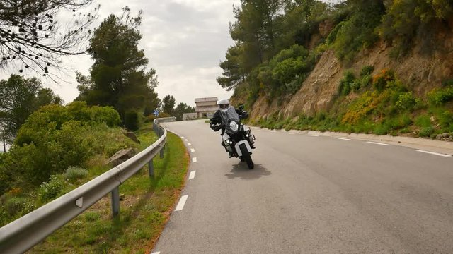 Motorcyclist Driving his Sports Motorbike on a Curvy Road.
Steady cam shot of a young man with his motorbike in spring.
Front view of a cross motorcycle in action on a scenic road in Catalonia.