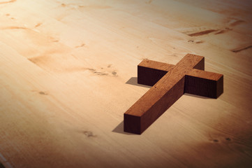 Wooden cross against bleached wooden planks background