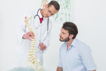 Male doctor explaining the spine to a patient