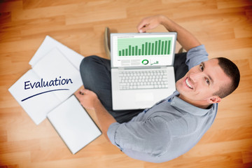 The word evaluation and business interface with graphs and data against young creative businessman working on laptop