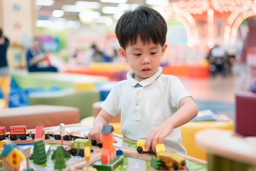 A boy is playing the city toys.