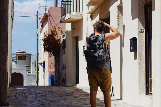 Traveller with camera and backpack takes pictures of the foreign city during the vacation, Crete, Greece