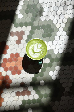 Matcha latte on tile background