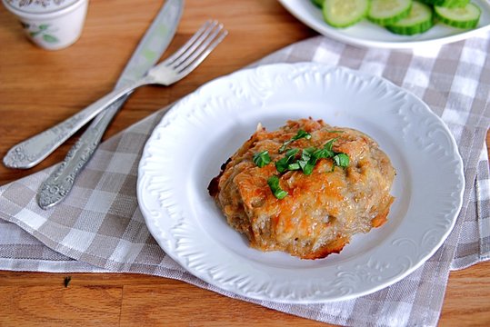 Baked grated potato with fish filling, sprinkled with cheese