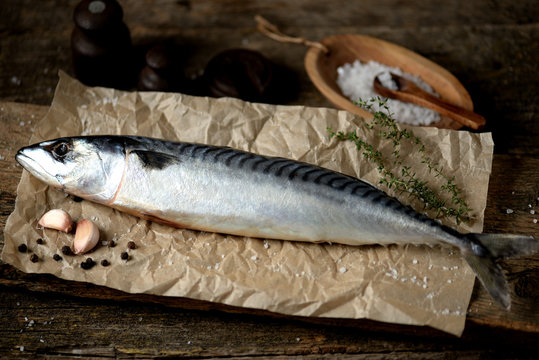 Fresh raw mackerel on an old wooden background.