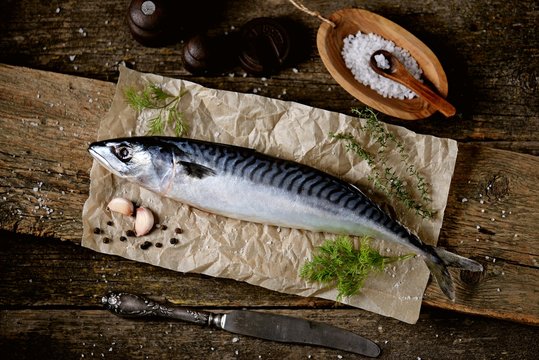 Fresh raw mackerel on an old wooden background.