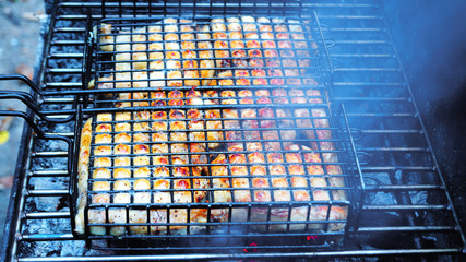 Preparation of chicken meat on a high stationary barbecue on the nature 