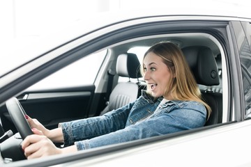 Fototapeta na wymiar Screaming girl rides behind the wheel of a car