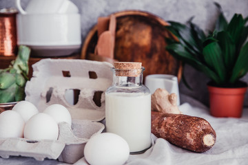 Still life in Rustic style fresh eggs, milk, artichoke on linen table. Organic eco farm products